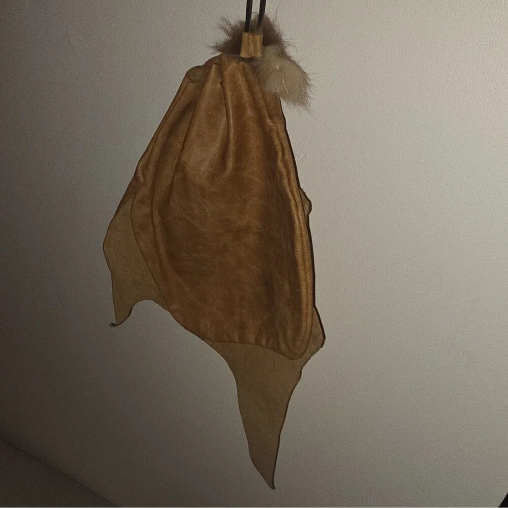 Handcrafted tan leather drawstring pouch featuring a soft fur pom-pom